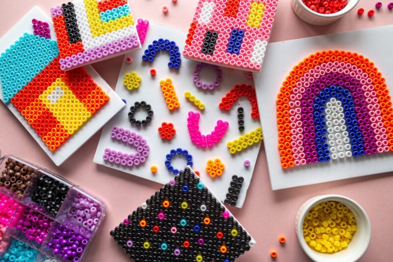 an assortment of beads is shown and a rainbow on a piece of paper created from them.